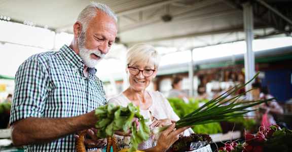 an older couple shopping at a farmers market