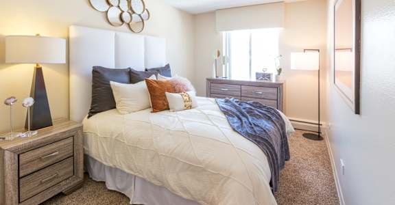 A bedroom with a large bed and a dresser.
