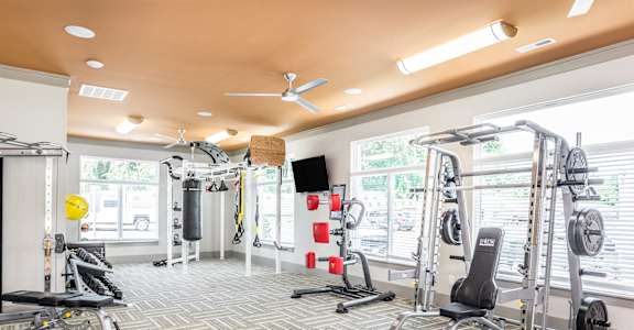 a gym with weights and other exercise equipments and windows