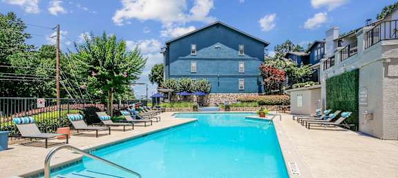 A blue building with a pool in front of it.