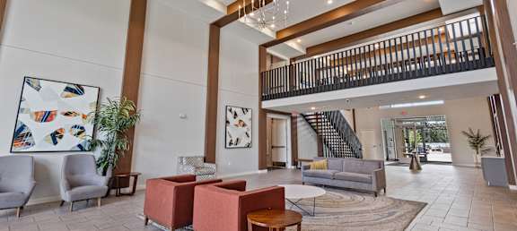 a lobby with couches and chairs and a staircase