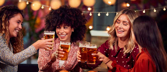 friends sitting at a table drinking beer and eating food