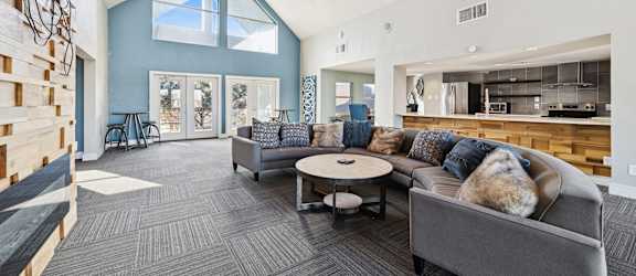 A modern living room with a grey couch and a round coffee table.