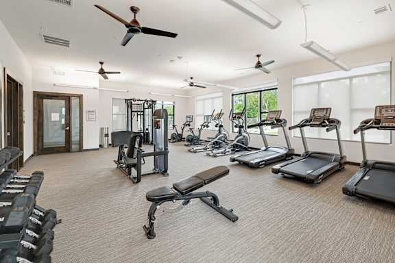 A spacious gym with treadmills, weights, and exercise equipment.