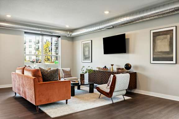 A living room with a brown couch, a chair, and a television.