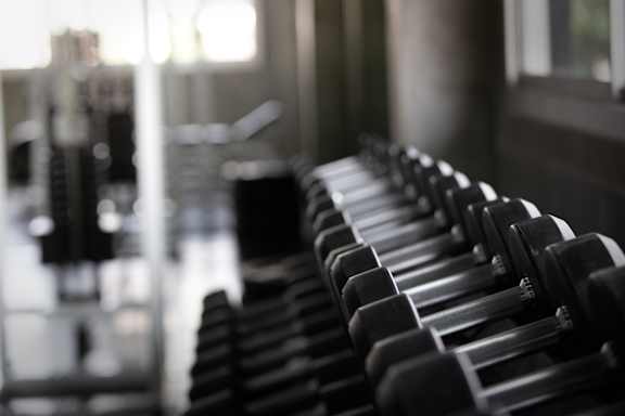 A gym with a variety of equipment including treadmills, weights, and exercise machines at Hampton Plaza Apartments, Towson, MD, 21286