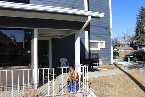 A house with a white porch and a black truck parked in the driveway.