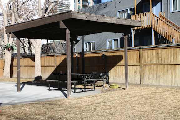 A wooden pergola with a bench underneath it.