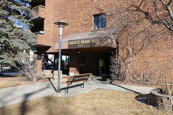 Grace Manor building with a bench in front.