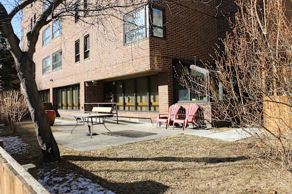 A brick building with a patio and chairs.
