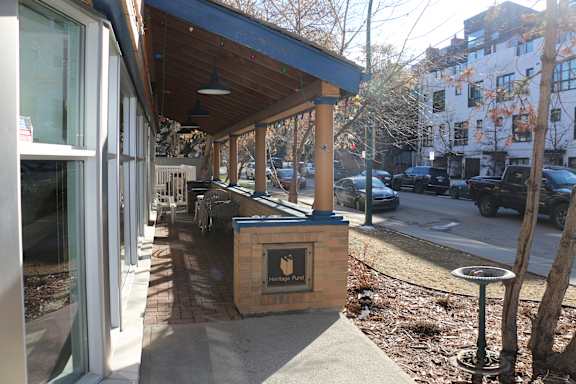 A small building with a black sign on it.