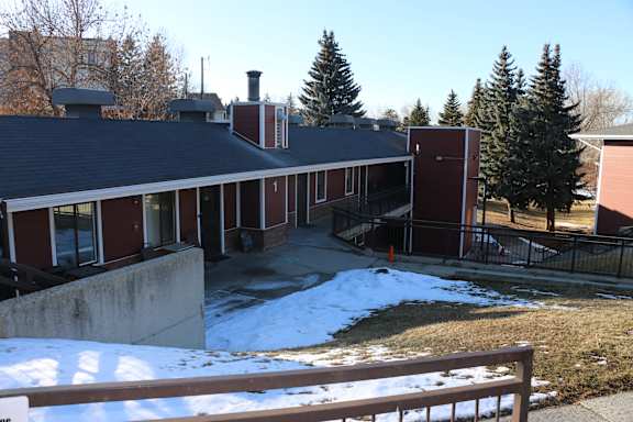 A snow-covered ground with a building in the background.