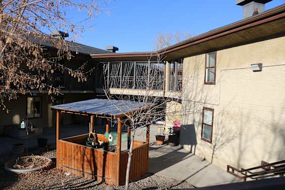 A small wooden shed with a metal roof is in the foreground of a residential area.