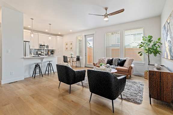 A modern living room with a black chair and a wooden floor.
