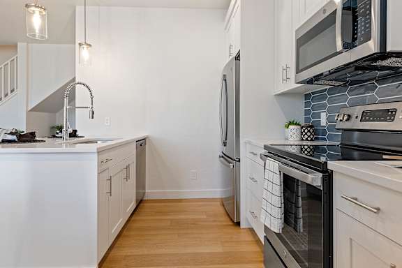 A kitchen with white cabinets and a black stove top.