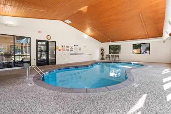 A large indoor swimming pool with a wooden ceiling.