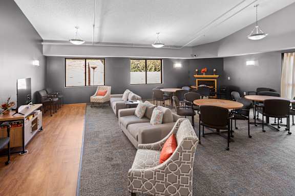 A living room with a grey couch and a wooden table.