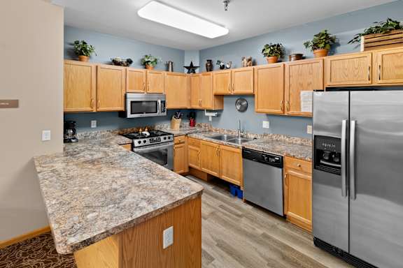 A kitchen with wooden cabinets and granite countertops.