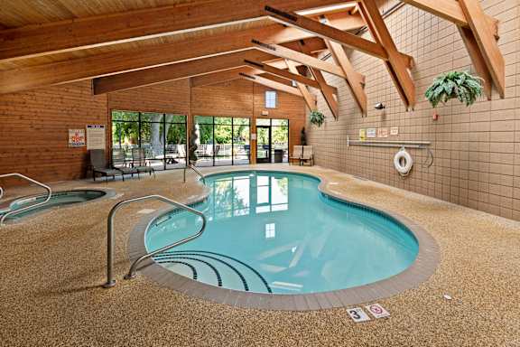 A small indoor pool with a brown floor and ceiling.