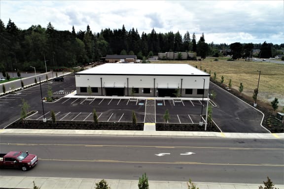 a rendering of a shopping center with a blank billboard in a parking lot