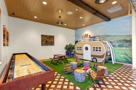 A room with a pool table and a picture of a trailer on the wall.