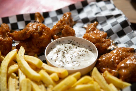 a board of chicken wings with fries and celery at The Box, Virginia
