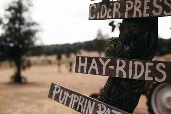 A signpost with the words Cider Press, Hay-Rides and Pumpkin Patch.