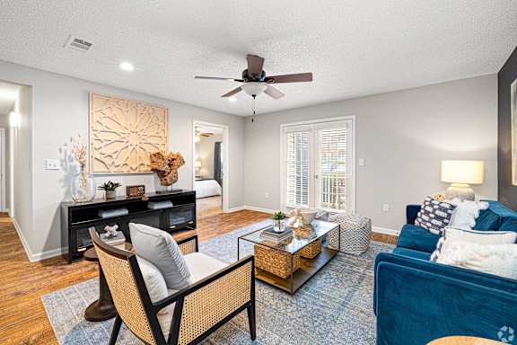 a rendering of a living room with a kitchen in the background at Park Place Apartment Homes, Hattiesburg, MS