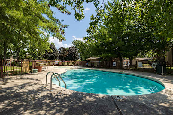 A view of the poolside at Skyler Ridge Apartments, offering a tranquil setting with lounge chairs and refreshing water.
