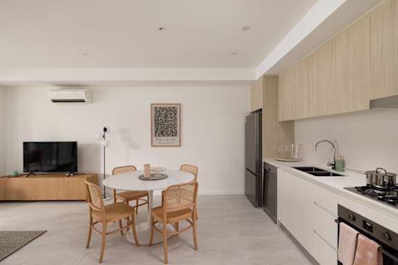 A modern kitchen with a dining table and chairs.