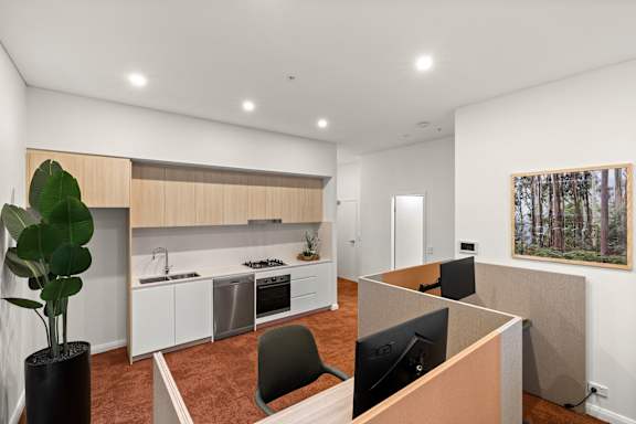 A modern kitchen with a white ceiling and a painting on the wall.