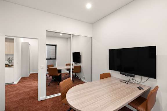A conference room with a large table and chairs.