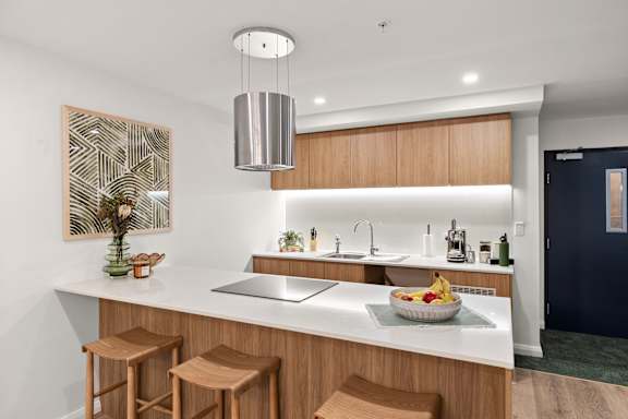 A modern kitchen with wooden cabinets and a white countertop.