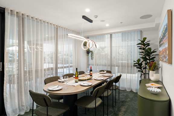 A dining room with a table set for a meal.