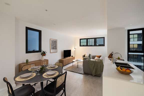 A modern dining room with a table set for two and a view of a city skyline.