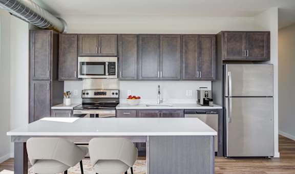 a kitchen with a white island and stainless steel appliances