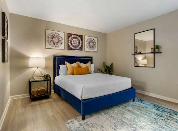 A bedroom with a blue bed and a white bedspread.