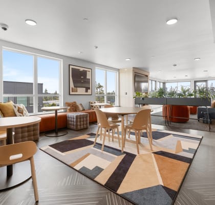 a seating area with tables and chairs at the enclave at woodbridge apartments in sugar land