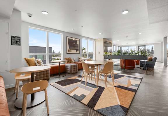 a seating area with tables and chairs at the enclave at woodbridge apartments in sugar land
