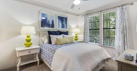 a bedroom with a large bed and two windows