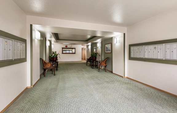 a hallway with chairs and tables and lockers on the wall