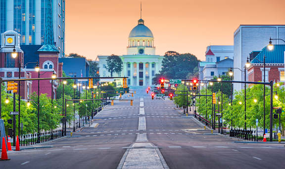 A city street with a large white dome building in the background.