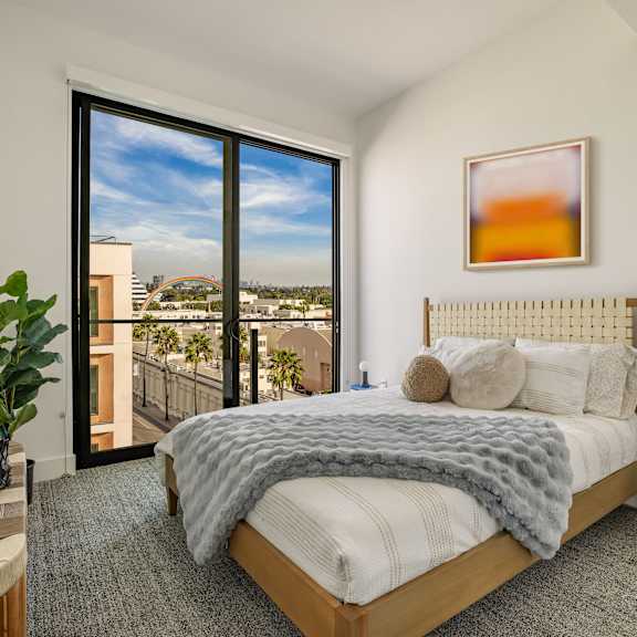 a bedroom with a bed and a large window with a city view at WM by CLG, California