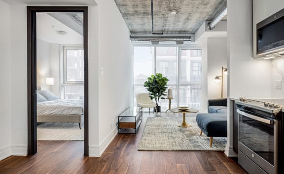 a bedroom with a bed and a tv in a room with hardwood floors at 150 Marketplace, Ottawa, K2J 5R5