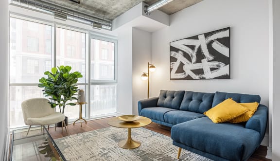 a living room with a blue couch and yellow pillows at 150 Marketplace, Ottawa, K2J 5R5