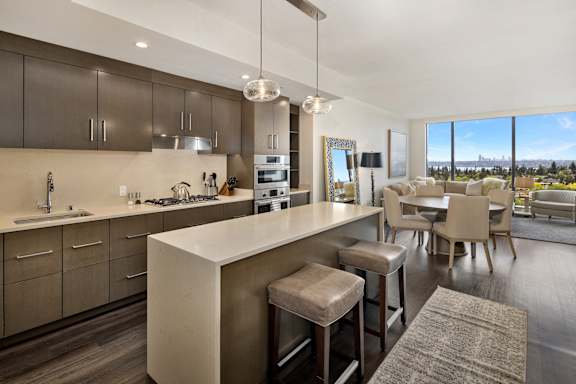 a kitchen with a large island and a dining room with a table and chairs at Two Lincoln Tower Apartments, Bellevue, WA, 98004