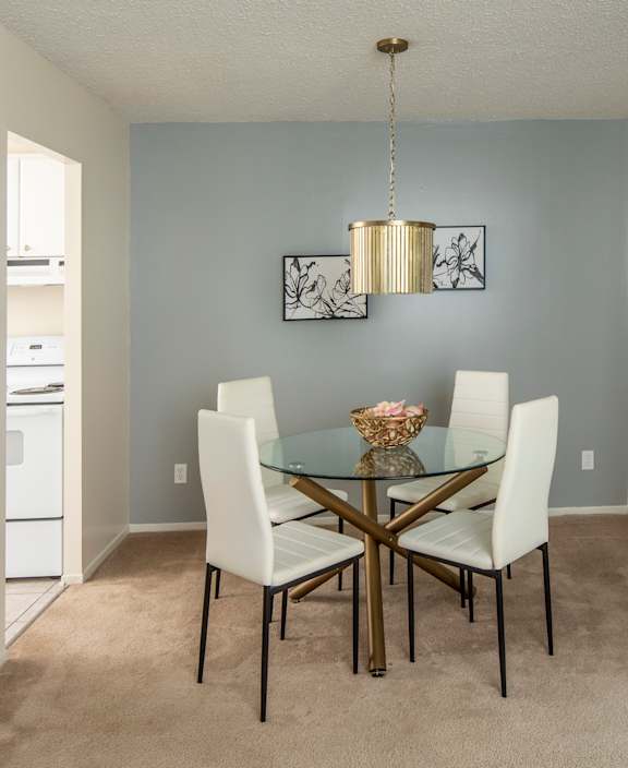 A living room with a white couch and a dining table.