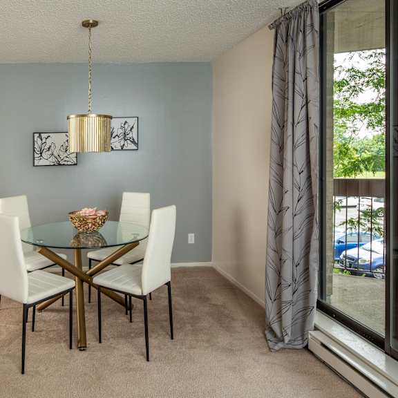 A dining room with a glass table and chairs.