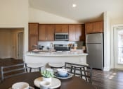 Thumbnail 8 of 11 - Kitchen with brown cabinets at Quarry Apartments and Townhomes in DeWitt, Michigan