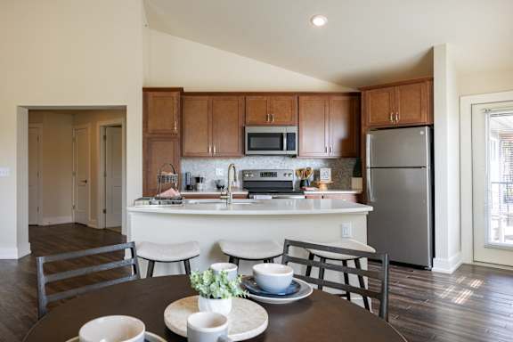 Kitchen with brown cabinets at Quarry Apartments and Townhomes in DeWitt, Michigan